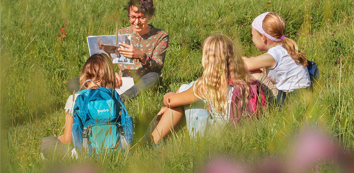 Bild von Kindern die im Gras sitzen